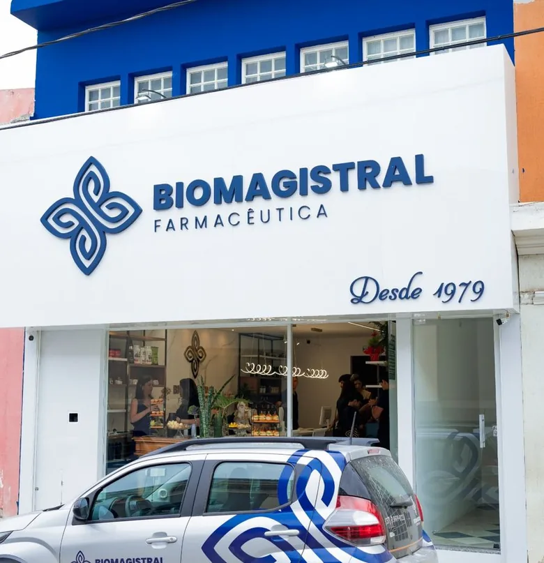Fachada branca e azul da Biomagistral Farmacêutica, com o letreiro Desde 1979